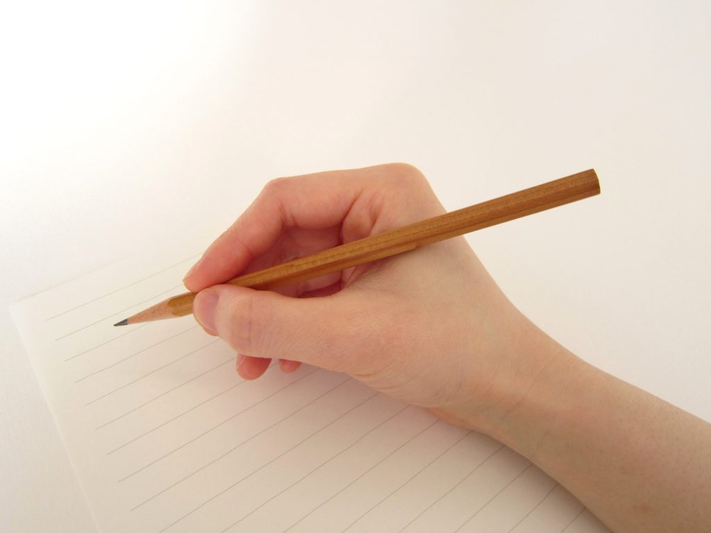 ノートに鉛筆で書き込む手